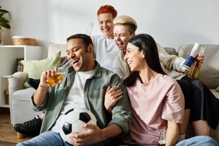 Foto de Un grupo diverso de personas sentadas encima de un sofá, disfrutando de la compañía de los demás en casa. - Imagen libre de derechos