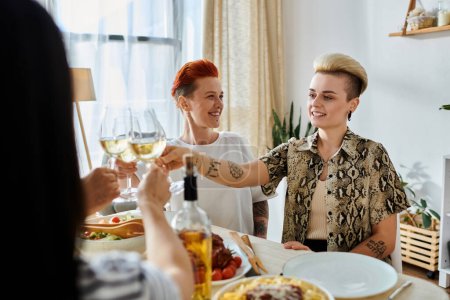 Téléchargez les photos : Un groupe diversifié de femmes assises autour d'une table, tenant des verres à vin, avec des amis. - en image libre de droit
