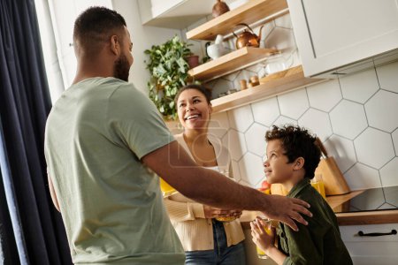 A man and woman spending time with their son in a warm kitchen setting.