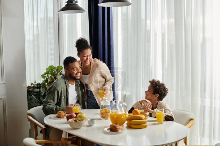 Famille afro-américaine multigénérationnelle profitant de temps de qualité ensemble à la table blanche.