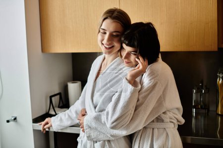 A young lesbian couple in bath robes standing together, sharing a tender moment in a cozy kitchen setting.