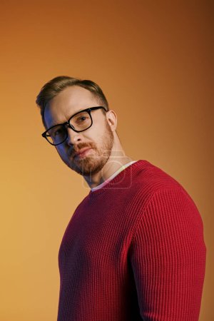 Stylish man in glasses and red sweater posing confidently.