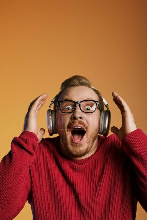 A stylish man wearing headphones looks surprised.