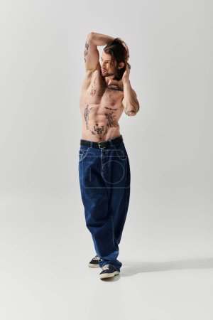 Un bel homme caucasien affichant des tatouages complexes sur sa poitrine et son corps torse nu.