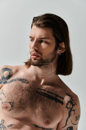 Elegante hombre caucásico con el pelo largo y tatuajes en el pecho.