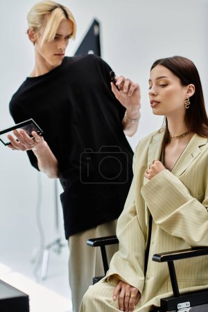 A makeup artist carefully applies makeup on a seated woman.