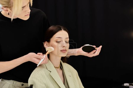 A makeup artist gracefully applies makeup to a womans face with a brush.