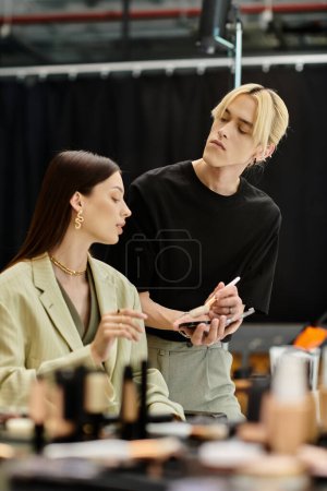 A man stands beside a woman in front of a mirror, applying makeup.