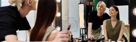 Woman looking in mirror, with her makeup artist.
