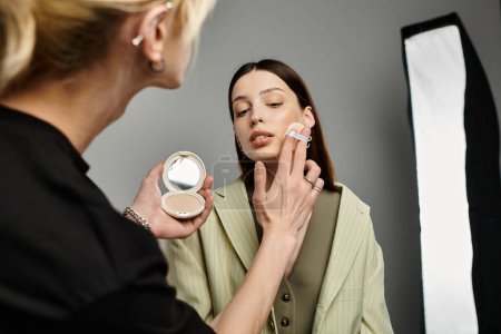 A makeup artist delicately applies makeup to a womans face.