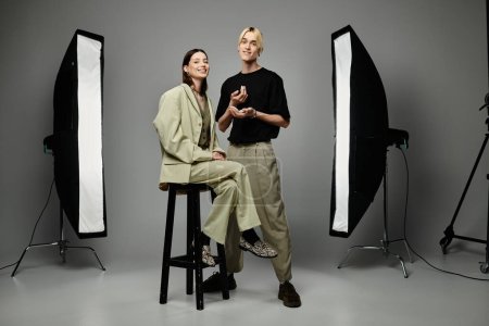 Male makeup artist beautifies female client in front of photo gear.