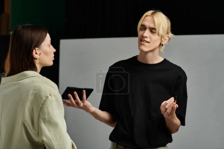 A woman is in conversation with a man wearing a black shirt.