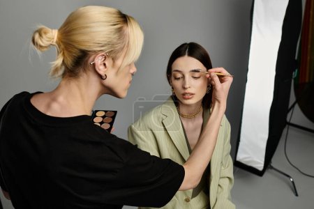 A woman receiving professional makeup application from a skilled artist.
