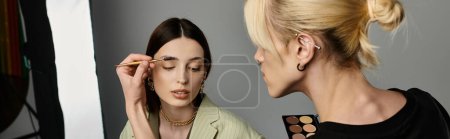 An artist applies makeup on a womans face.