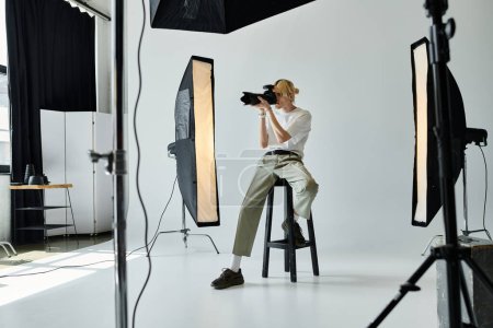 Photo for A man sitting on a stool, photographing. - Royalty Free Image