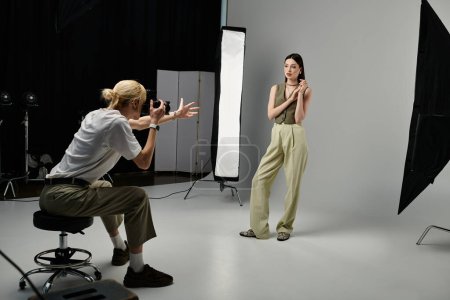 A woman stands confidently in a studio, posing for the camera.