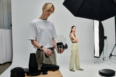 A man holding a camera stands beside a woman.