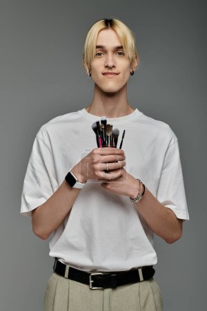 A man holds multiple brushes in his hands.