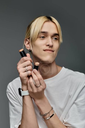 A fashionable man with blonde hair and a ring on his finger, striking a pose.