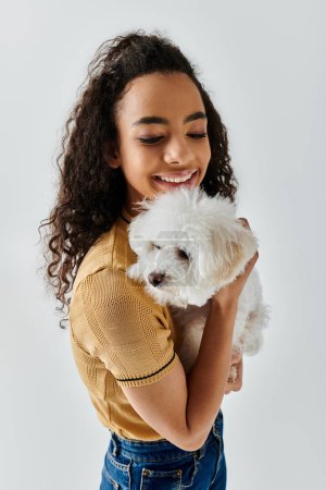 A woman lovingly holds her white bichon frise in her arms.