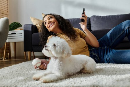 Woman sitting with her bichon frise on floor