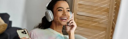 Photo for Young woman in headphones using cell phone. - Royalty Free Image