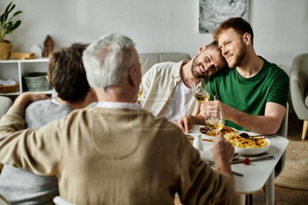 Un couple gay s'assoit à une table à manger avec sa famille, profitant d'un repas et d'une conversation.