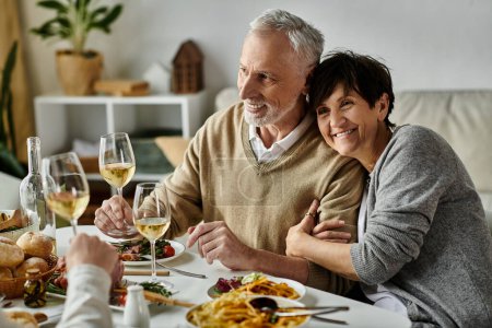 Los padres felices comparten la comida con su hijo y su pareja en una cena acogedora en casa.