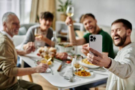 Ein schwules Paar macht während einer Mahlzeit ein Selfie mit seiner Familie.