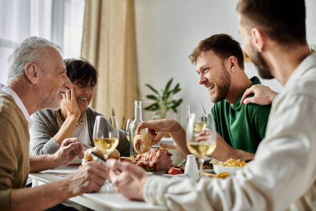 Ein schwules Paar genießt eine Mahlzeit mit seiner Familie zu Hause.