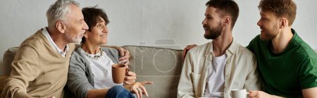 A gay couple sits on a couch with parents, engaging in a warm and meaningful conversation.