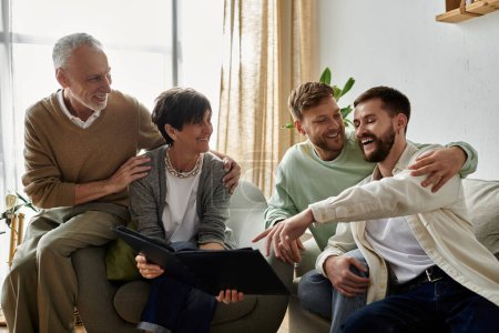 Un couple gay partage un rire avec les parents en regardant un album photo.