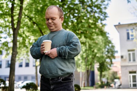 Ein Mann mit Inklusivität genießt einen Kaffee an einem warmen Nachmittag, umgeben von Bäumen.