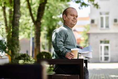 A man with inclusivity sits on a park bench, enjoying a cup of coffee and reading a newspaper.