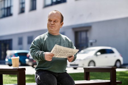 A man with inclusivity sits on a bench outdoors, reading a newspaper on a sunny day.