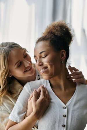 Zwei Frauen, ein vielfältiges lesbisches Paar, teilen einen zärtlichen Moment zu Hause.
