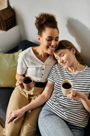 Photo for A loving lesbian couple relaxes at home, enjoying coffee and each others company. - Royalty Free Image