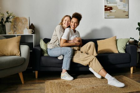 Photo for A lesbian couple shares a loving embrace while relaxing on a sofa. - Royalty Free Image