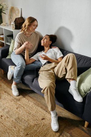 Un couple de lesbiennes partage un moment tendre sur un canapé à la maison.