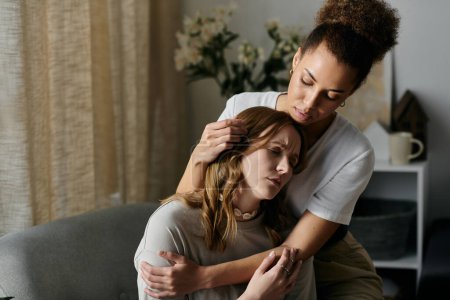 A lesbian couple shares a tender moment of comfort and love in their home.
