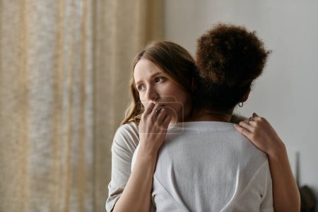 A lesbian couple embraces, finding solace in each others presence within their home.