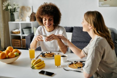 Dos mujeres disfrutan de un desayuno informal en casa.
