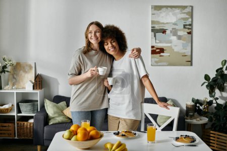 Photo for Two women in casual attire enjoy a cup of coffee together in their home. - Royalty Free Image