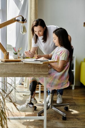 A mother helps her daughter with a drawing project at their home. The daughter has a prosthetic leg.