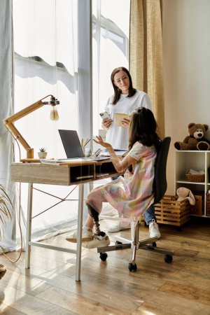 Eine brünette Mutter und ihre Tochter, die eine Beinprothese hat, machen zu Hause gemeinsam Hausaufgaben.