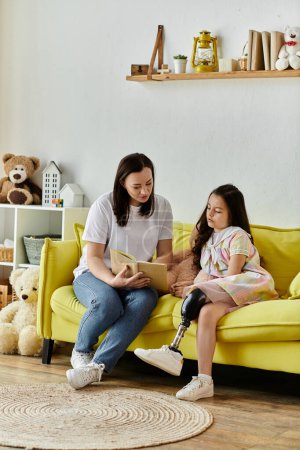 A mother and her daughter sit on a yellow sofa reading a book. The daughter has a prosthetic leg.