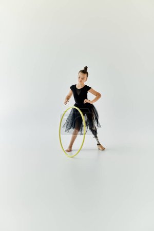 A young girl with a prosthetic leg practices gymnastics with a hoop.