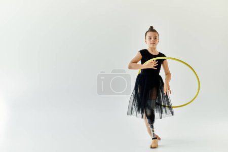 A young girl with a prosthetic leg practices gymnastics with a hoop.