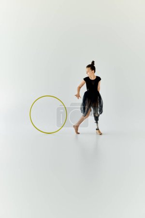 Una joven con una pierna protésica practica gimnasia con un aro hula.