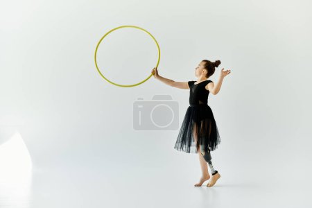 Une jeune fille avec une prothèse de jambe pratique la gymnastique avec un cerceau.